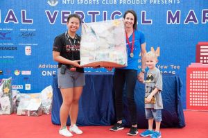 Walsham collects her unique winner's prize, which looks like a package of wrapped groceries!!